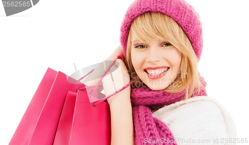 Image of woman in pink hat and scarf with shopping bags