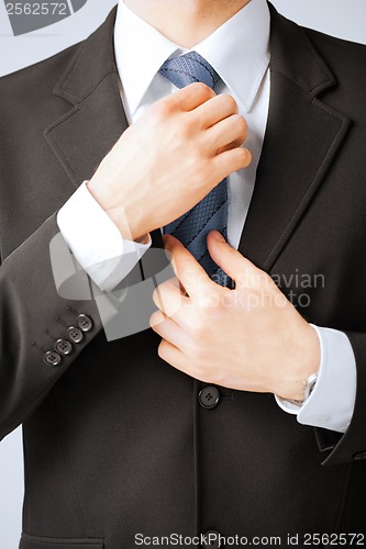 Image of man adjusting his tie