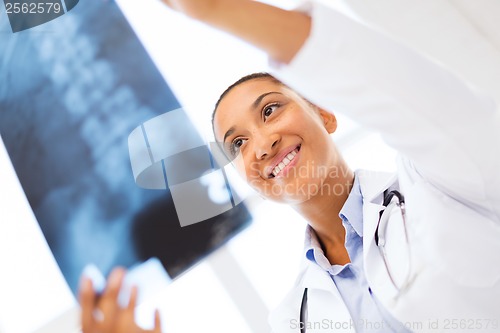 Image of smiling female doctor studying x-ray