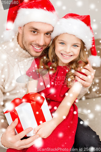 Image of smiling father and daughter holding gift box