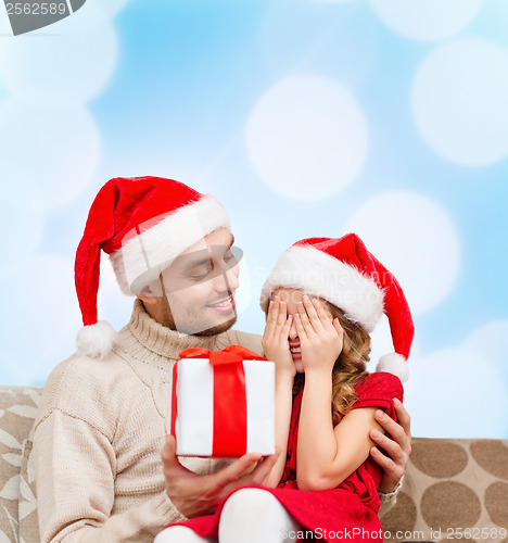 Image of smiling daughter waiting for a present from father