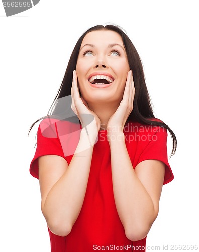 Image of amazed laughing young woman in red dress