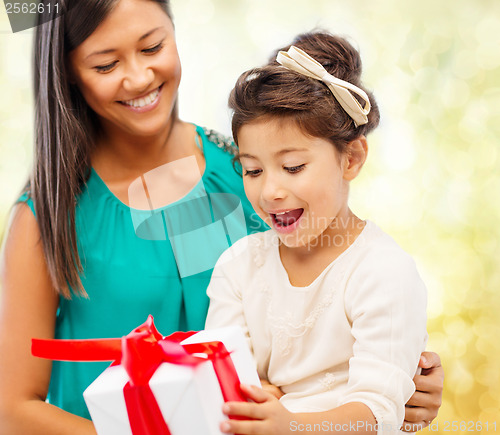 Image of happy mother and child girl with gift box