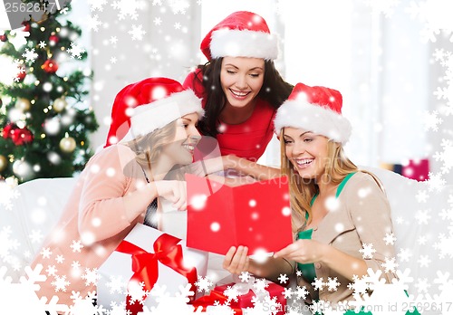 Image of women in santa helper hats with card and gifts