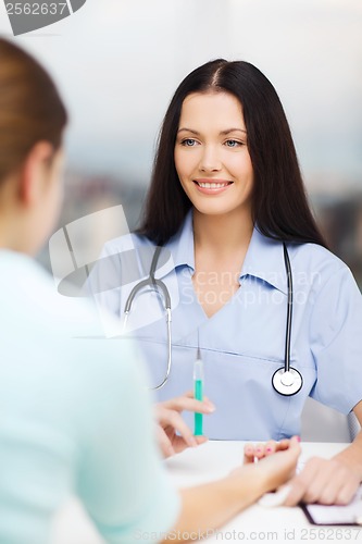 Image of smiling female doctor or nurse with syringe