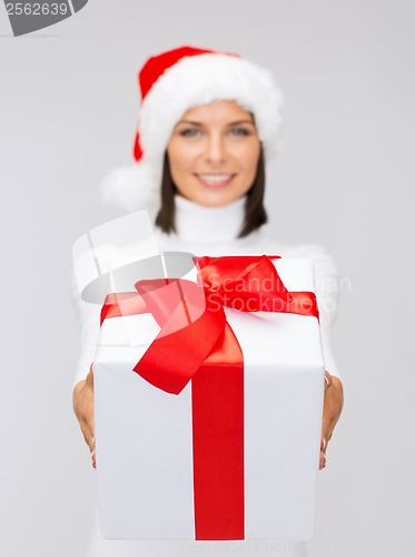 Image of woman in santa helper hat holding gift box