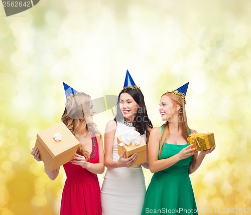 Image of three smiling women in blue hats with gift boxes