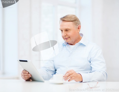 Image of old man with tablet pc computer at home