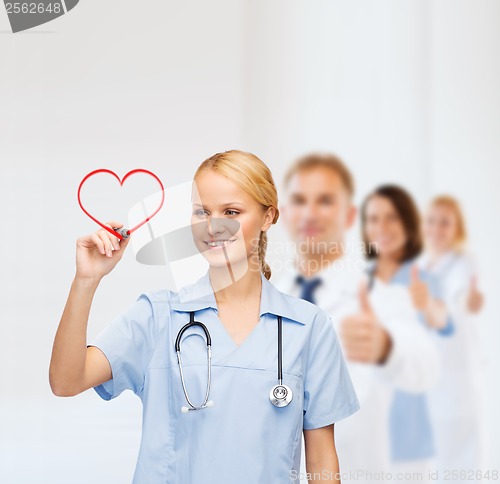 Image of smiling doctor or nurse drawing red heart