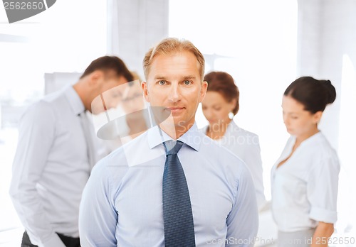 Image of businessman in office with group on the back