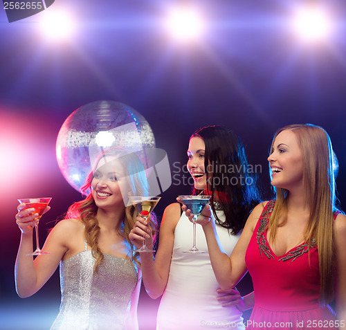 Image of three smiling women with cocktails and disco ball