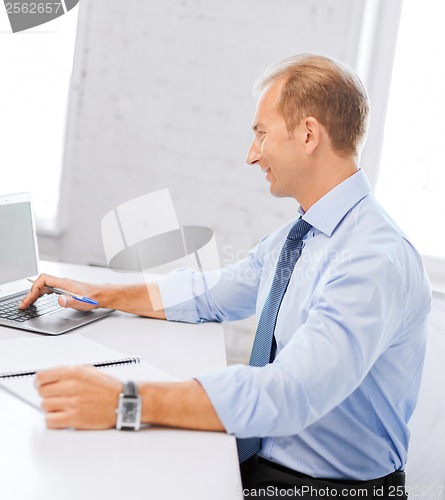 Image of smiling businessman working in office