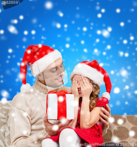 Image of smiling daughter waiting for a present from father