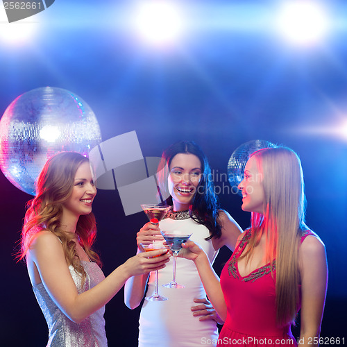 Image of three smiling women with cocktails and disco ball