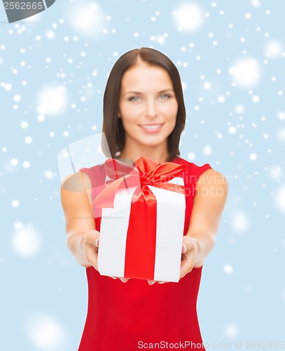 Image of smiling woman in red dress holding gift box