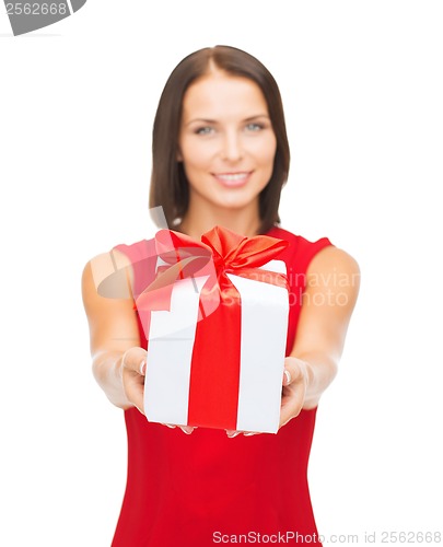 Image of smiling woman in red dress holding gift box