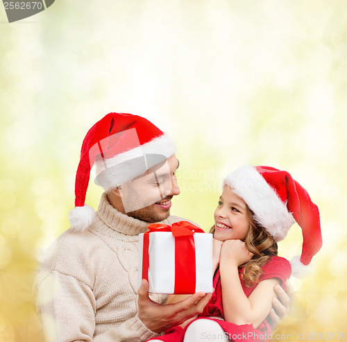 Image of smiling father giving daughter gift box