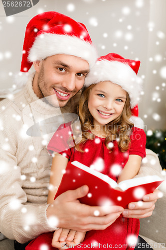 Image of smiling father and daughter reading book