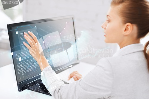 Image of smiling businesswoman with touchscreen in office