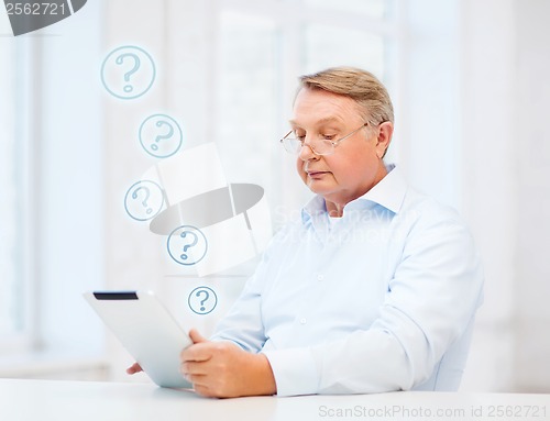 Image of old man with tablet computer at home