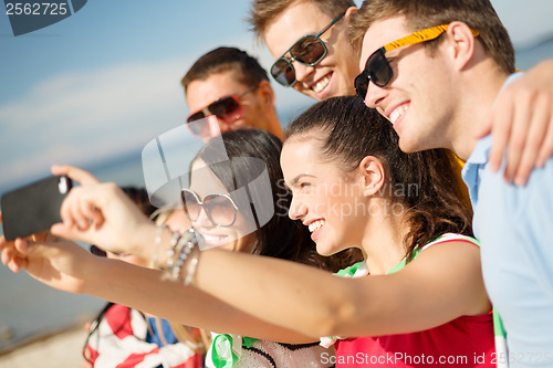 Image of group of friends taking picture with smartphone