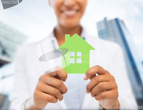 Image of woman hands holding green house