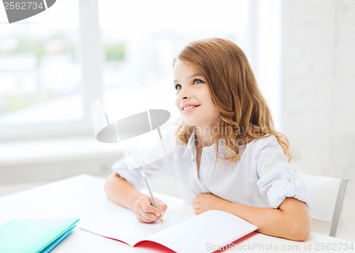 Image of student girl writing in notebook at school