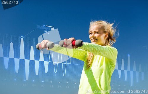 Image of sporty woman with light dumbbells outdoors