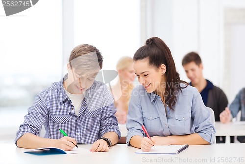 Image of two teenagers with notebooks at school