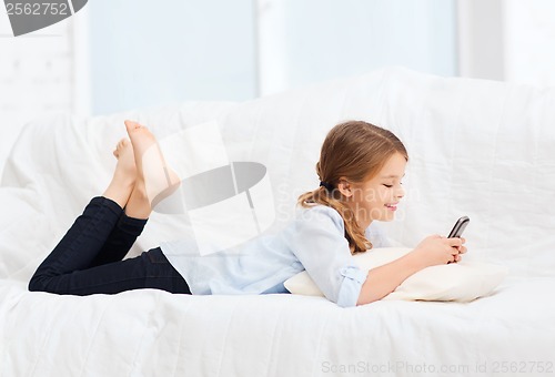 Image of smiling girl with smartphone at home