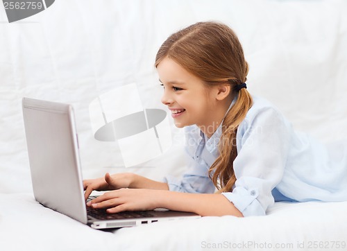 Image of smiling girl with laptop computer at home