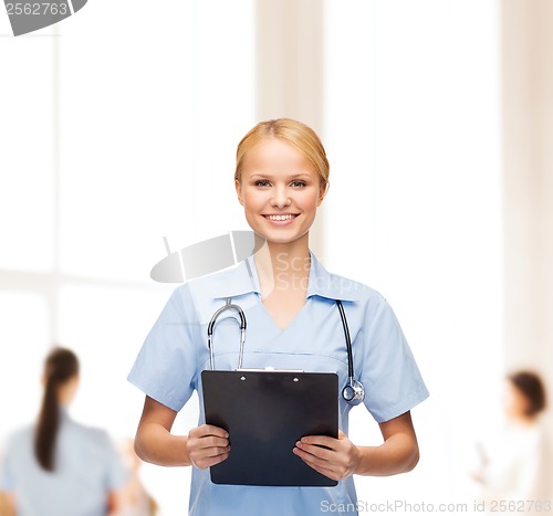 Image of smiling female doctor or nurse with clipboard