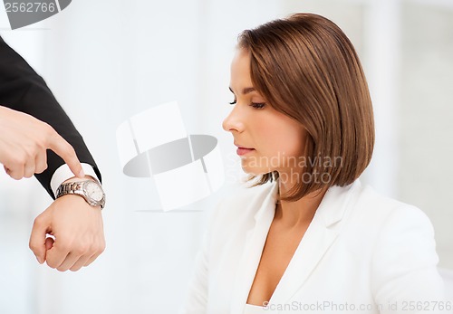 Image of boss showing time to stressed businesswoman
