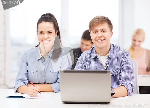 Image of students with laptop and notebooks at school