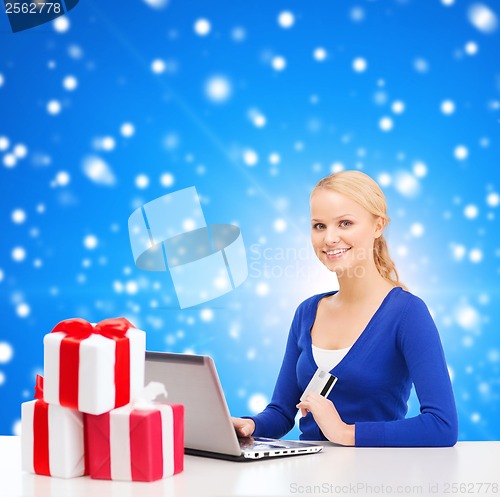 Image of woman with gifts, laptop computer and credit card