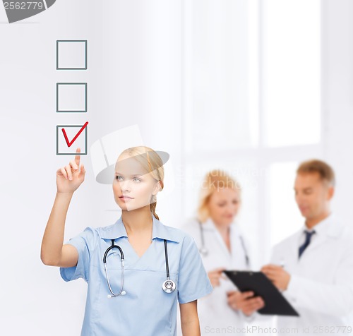 Image of smiling doctor or nurse pointing to checkmark