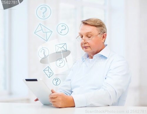 Image of old man with tablet computer at home