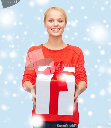 Image of smiling woman in red sweater with gift box