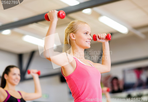 Image of group of smiling people working out with dumbbells