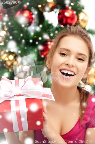 Image of happy woman with gift box and christmas tree