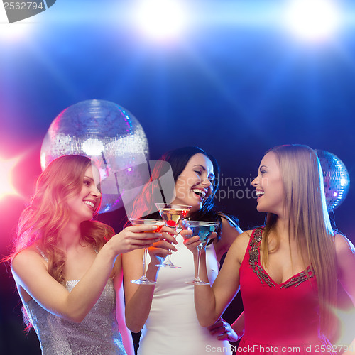 Image of three smiling women with cocktails and disco ball