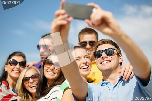 Image of group of friends taking picture with smartphone