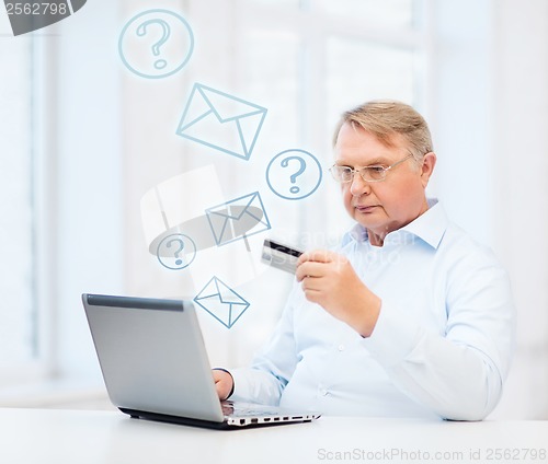 Image of old man with laptop and credit card at home