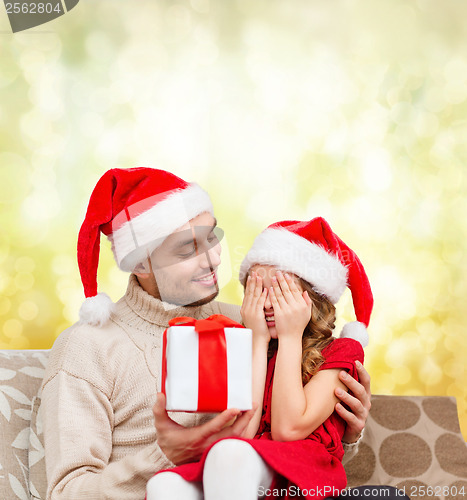 Image of smiling daughter waiting for a present from father