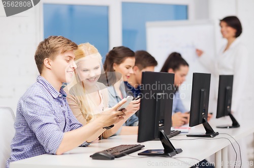 Image of students with computer monitor and smartphones