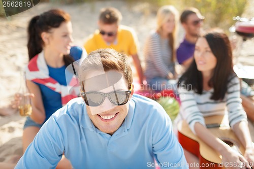 Image of smiling man in sunglasses on the beach