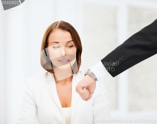 Image of boss showing time to stressed businesswoman