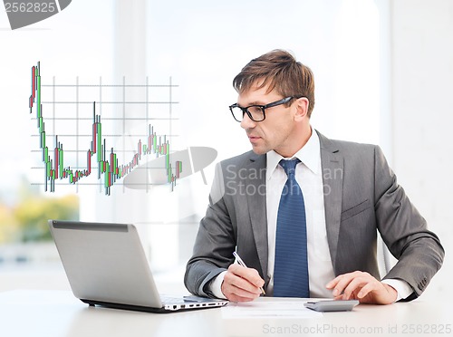 Image of businessman with computer, papers and calculator