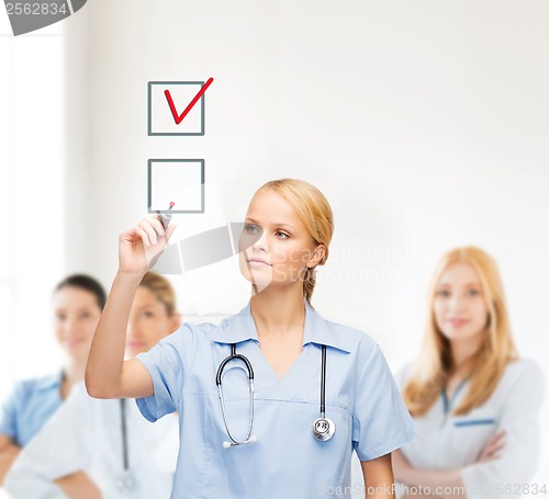 Image of doctor or nurse drawning checkmark into checkbox