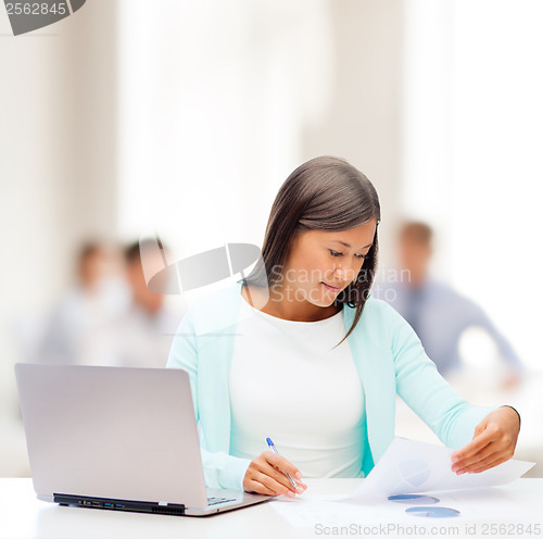 Image of asian businesswoman with laptop and documents